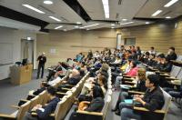 Prof. Burbach (standing) gives a talk to our School members